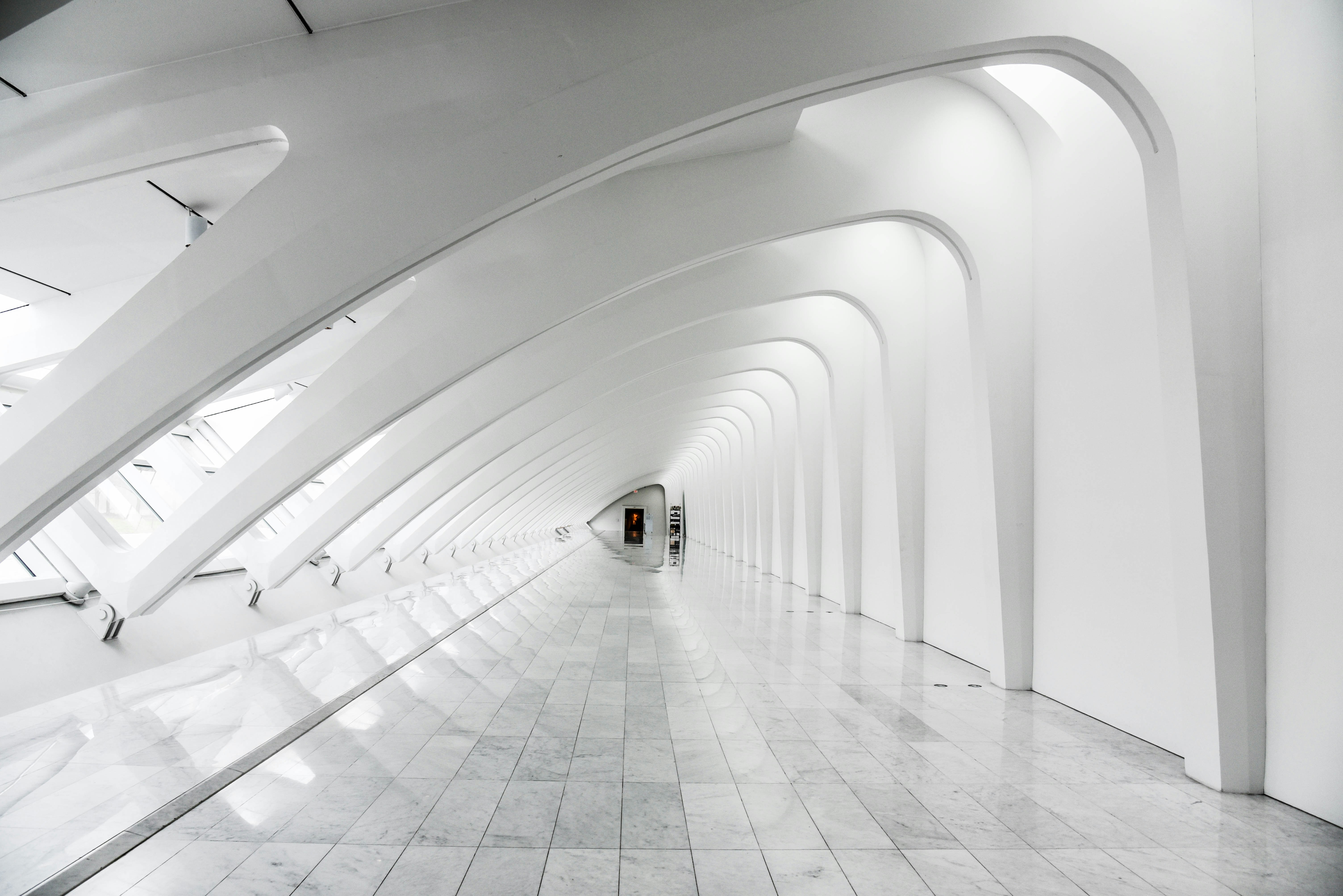 Interior of a long white hall with curved walls